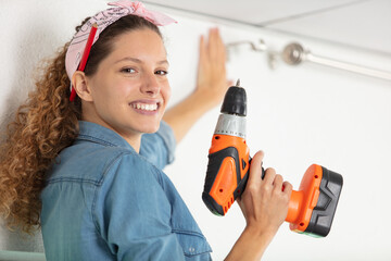 woman drilling wall in new house