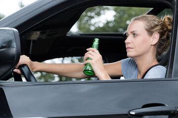 woman drinking beer while driving car