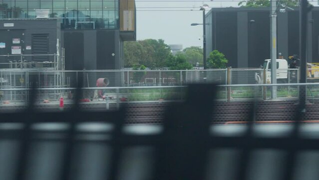 Filming out of a train window during the early dawn passing railway lines and a train yard in Sydney Australia