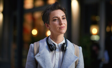 Business woman in city, thinking with face and travel to work with headphones outdoor, mockup with bokeh and commute. Young creative, mindset and vision with web designer, career and growth in London