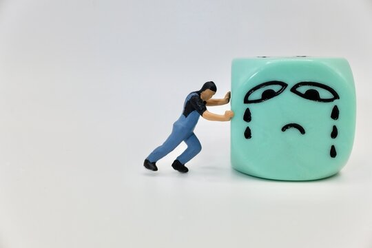 miniature figurine of a man chasing away the icon of sadness