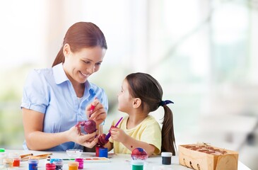 A smart child studies with a teacher or mother