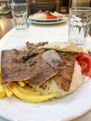 Traditional meat doner kebab on rice or turkish pilav on plate in turkey. 