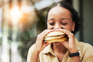 Happy, fast food and black woman eating a sandwich in an outdoor restaurant as a lunch meal craving...