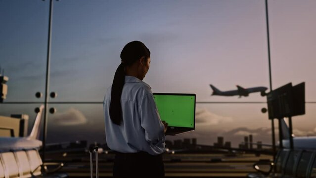 Asian Woman Using Green Screen Laptop In Boarding Lounge At The Airport
