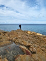 uomo solitario su scoglio di fronte al mare