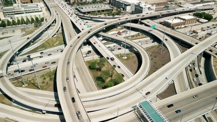 Above wide aerial drone shot of cars driving over elevated highway and busy interchange near Chicago. 