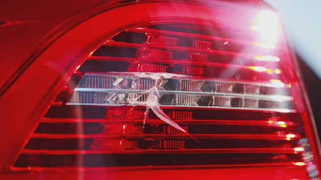 Damaged car brake light, crack and broken tail light. Concept of transport insurance, accident, close-up, Slow motion