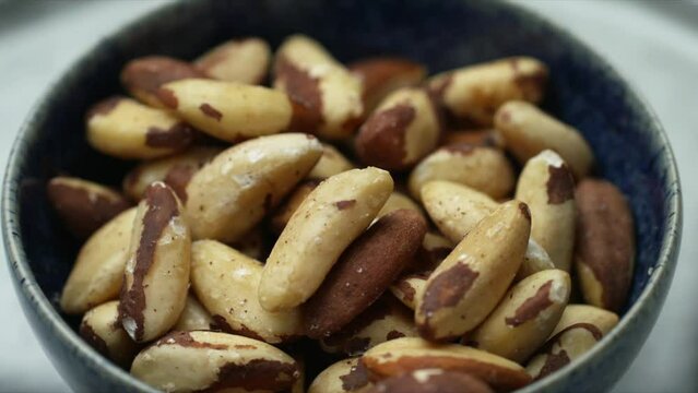 Brazil nuts rotating in bowl. raw wholefood and healthy foods. Whole food cooking for vegetarian and plant-based diet. Shallow depth of field HD image of healthy vegan food.