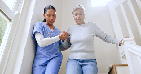 Woman, nurse and helping senior on stairs in retirement home for support, trust or healthcare. Female person, medical caregiver holding hands with retired or mature patient down a staircase at house - obrazy, fototapety, plakaty
