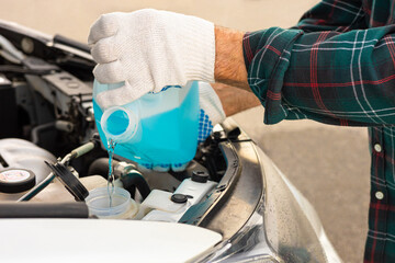 the driver pours antifreeze into the car
