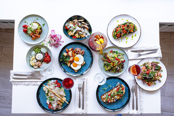 a lot of different beautiful food on a white wooden table