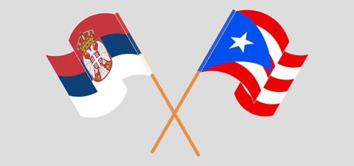 Crossed and waving flags of Serbia and Puerto Rico