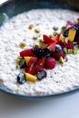 semolina porridge with berries in a plate on the white table