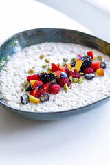 semolina porridge with berries in a plate on the white table