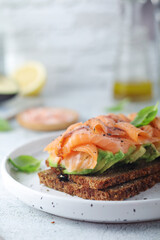 A rye bread sandwich with avocado and salmon