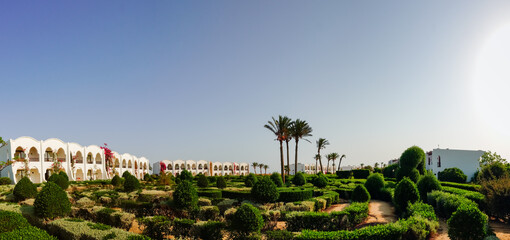 white houses with a wonderful green garden and deep blue sky on vacation in egypt panorama