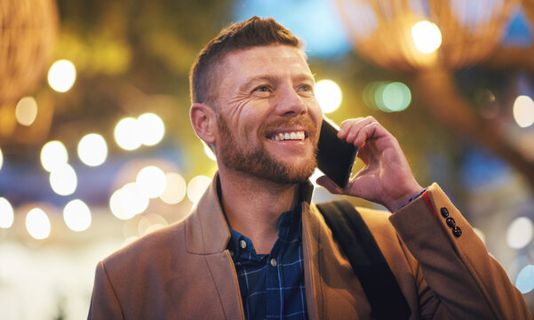 Phone call, business man and talking in city, chatting or speaking to contact at night. Bokeh, thinking or happy male entrepreneur with 5g mobile smartphone for networking, discussion or conversation