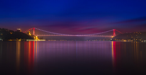 Colourful panoramic view of the Bosphorus at dawn. Rumeli tower and Fatih Sultan Mehmet bridge.  Turkey 