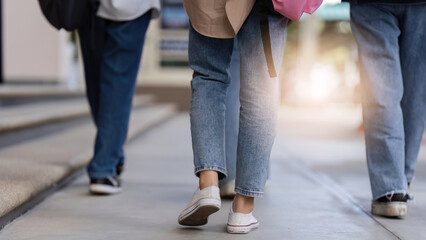university students using a digital tablet while walking to next class
