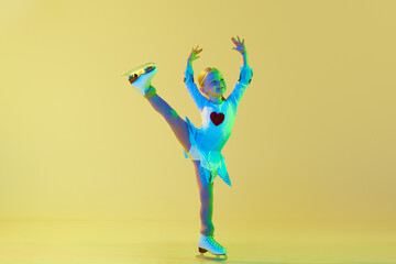 Artistic, talented little girl, child, performing figure skating in beautiful costume against...