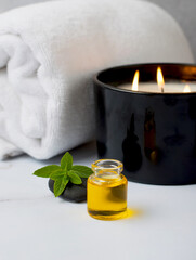 Spa treatments, massage, relaxation and beauty concept. Towel with candles and aroma oil, massage stone, on a marble background