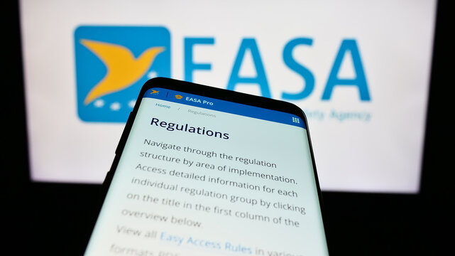 Stuttgart, Germany - 10-17-2023: Mobile phone with webpage of European Union Aviation Safety Agency (EASA) in front of logo. Focus on top-left of phone display.