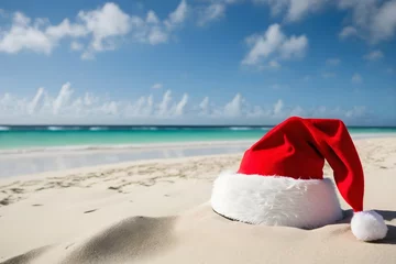 Foto op Plexiglas Red Santa hat on the sand of the beach © Elena