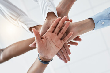 Hands, collaboration and motivation with a team in business standing in a huddle or circle from below. Teamwork, success and unity with an employee group working together with a goal or vision