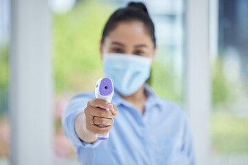 Hand, woman employee and covid thermometer laser for medical exam, check or covid 19 scan at office. Healthcare worker, mask and scan for corona virus safety and wellness protection at a workplace