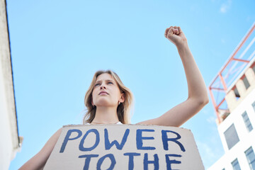 Power to the people, woman protest and freedom sign to fight human rights, justice and politics in street rally. Girl power, feminism revolution and poster to support equality, community and society © Wesley JvR/peopleimages.com