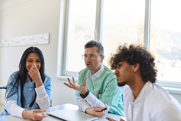 Fototapeta premium A dedicated group of doctors and medical nurses attentively listens to their colleague's work plan in a healthcare facility, fostering collaboration and ensuring high-quality patient care