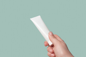 White Cream Package Template in Female Hand. Green Background. Natural Cosmetics Showing. Beauty...