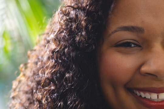 Portrait of happy african american woman in bright living room at home, close up