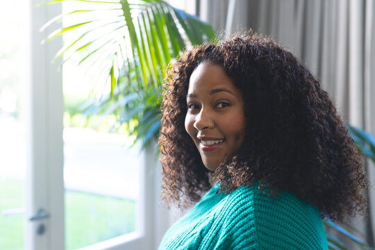 Portrait of happy african american woman in bright living room at home, copy space