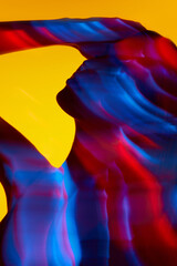 Silhouette of elegant woman against yellow background with multicolored mixed lights in neon color....