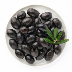Delicious black olives in plate with olive tree sprig decoration isolated on white background top view for your design. Healthy eating, healthy fats for humans. Organic vegetable