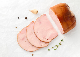 Smoked pork meat slices in a shell decorated with clove of garlic, spices, thyme sprig on white plate on an isolated white background top view for your design. Healthy food. Protein, vitamins