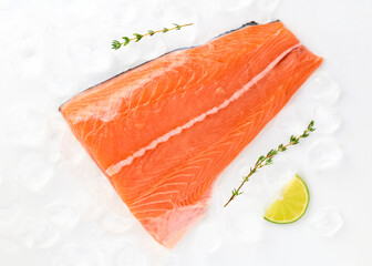Salmon fillet sea fish peeled laid out on pieces of ice decorated with lemon sprig of greens isolated on white background top view for design. Healthy food. Vitamins, Omega B12 healthy fats