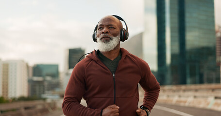 Mature, athlete and running in city with headphones for fitness, workout or marathon training...