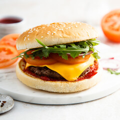 Traditional homemade cheeseburger with arugula