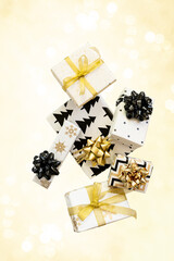 Creative composition of festive present boxes. Free levitation. Black and gold colors
