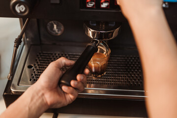 Top view, Hand of barista making coffee espresso pouring from espresso machine to cup. Espresso shot, Coffee making concept.
