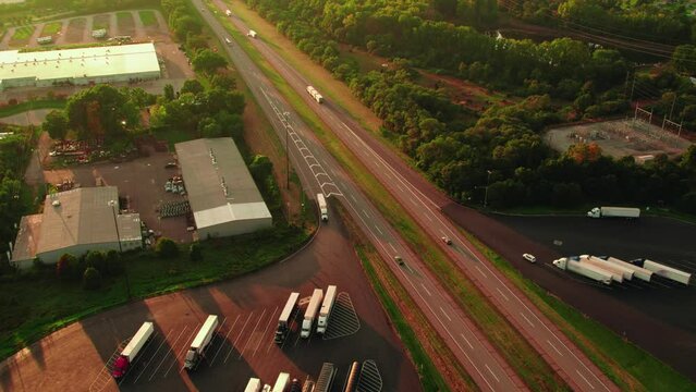 B-train trailers pulled by semi truck on Highway I-80 near Elkhart Paza truck stop. Cinematic sunset aerial