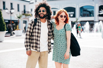 Smiling beautiful redhead  woman and her handsome boyfriend. Model in casual summer clothes. Happy cheerful family. Female having fun. Couple posing in the street at sunny day. Having tender moments