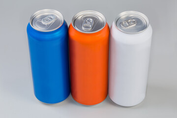 Sealed beverage cans of various colors on a gray background