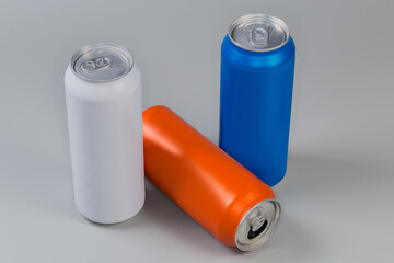 Sealed and open varicolored beverage cans on a gray background