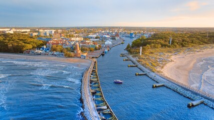 Drone photo captures Kołobrzeg's maritime charm, featuring the iconic lighthouse, cerulean sea,...