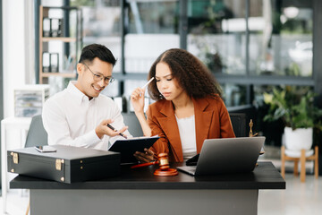 Obraz premium Asian business team and lawyers discussing contract papers sitting at the table. Concepts of law, advice, legal services. at modern office