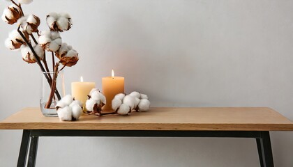Stylish table with cotton flowers and aroma candles near light wall. Banner for design , generated by AI. High quality photo